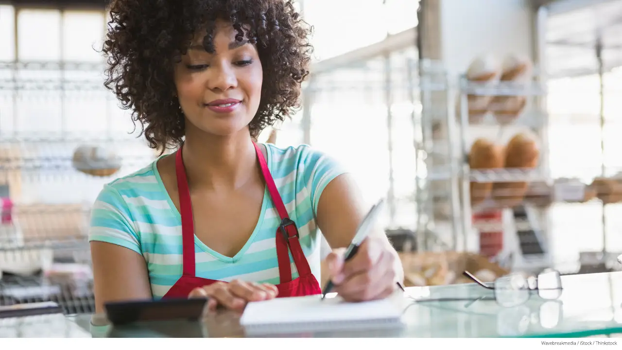 Smiling waitress writing on notepad